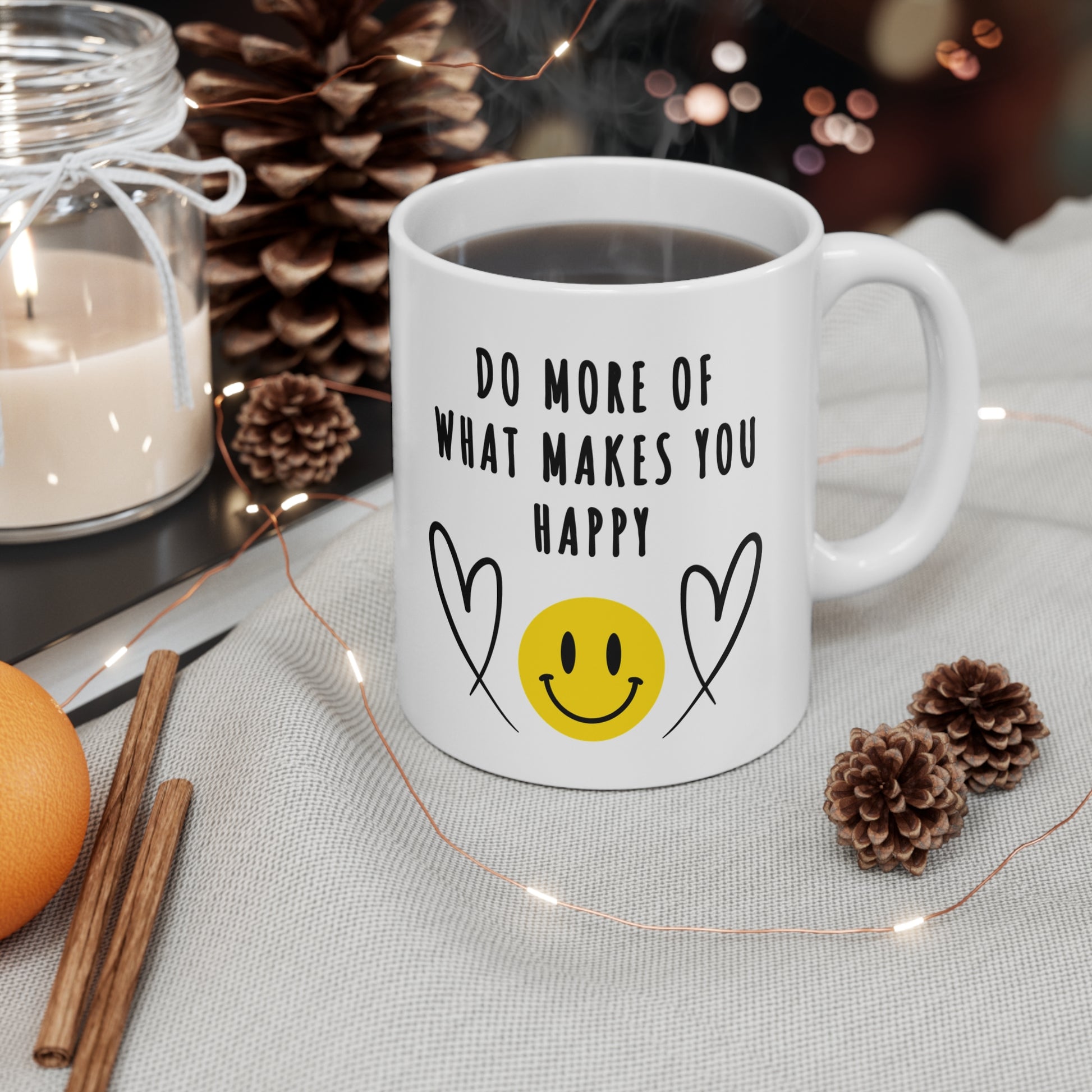 11 oz white ceramic mug with smiling emoji and hearts and 'Do More of What Makes You Happy' in bold black letters, uplifting and motivational design