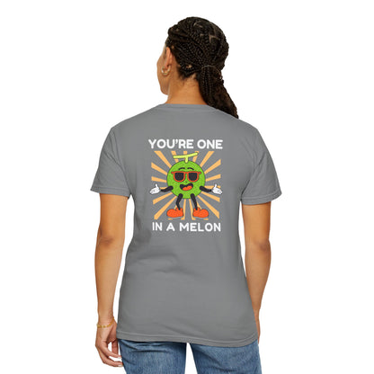 Woman wearing a grey unisex t-shirt with a large back design featuring 'You're One in a Melon' text and a smiling melon wearing sunglasses on a retro background, uplifting and fun graphic tee