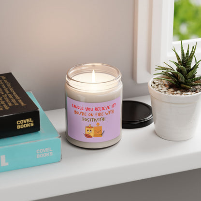 A soy candle in a 9oz in a glass jar with a phrase 'Candle You Believe It' on the label, featuring graphic of two smiling candles