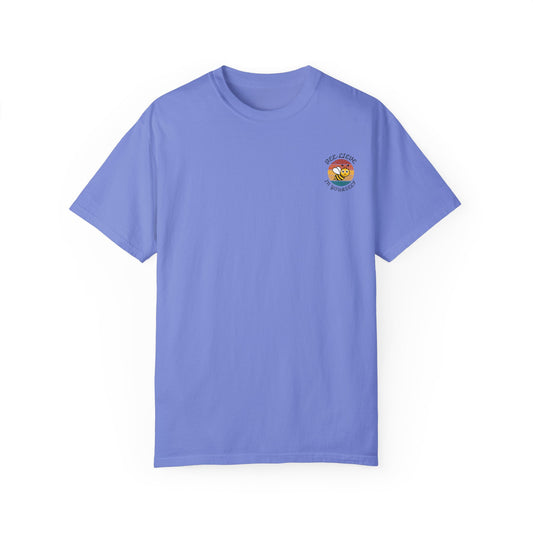 A blue unisex graphic t-shirt featuring a logo of a retro sunset background with a cute bee and phrase 'Bee-lieve in Yourself'